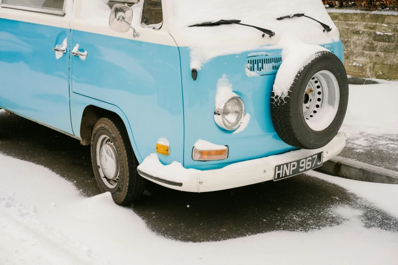 a blue and white van parked in the snow