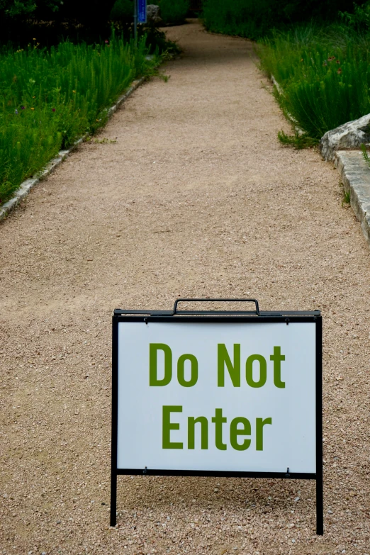a sign stating not to enter on a path