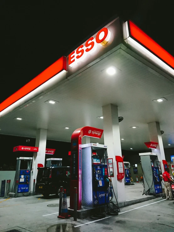 two empty gas pumps at night in an empty lot