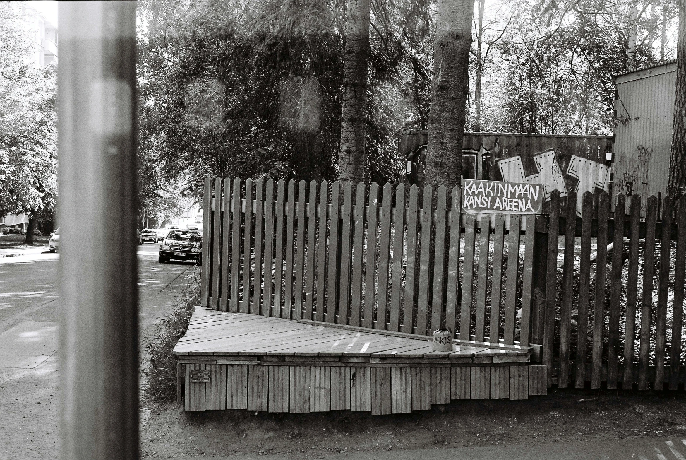 a wooden bench sitting next to a wooden fence