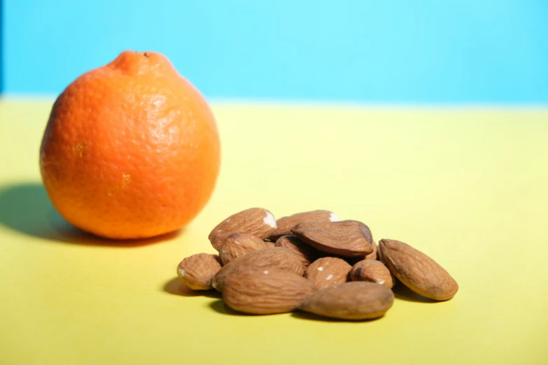 a group of almonds sit near a piece of orange