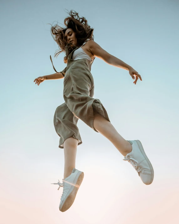 a woman jumping into the air on top of a skateboard