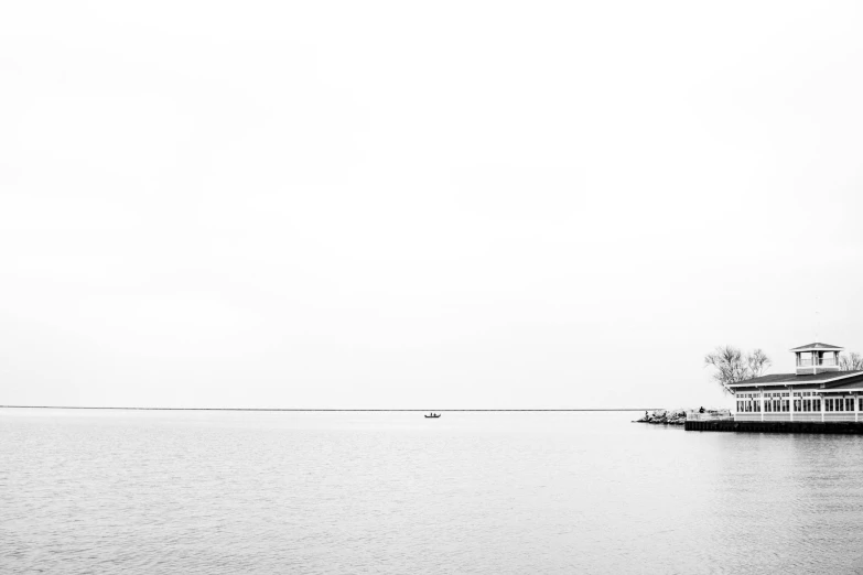 a small house sitting on the shore of a lake