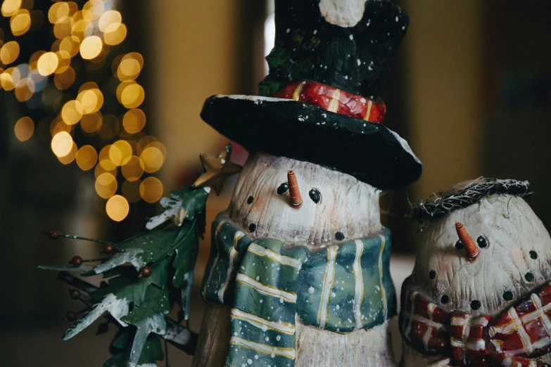 three snowmen wearing hats and scarfs standing next to each other