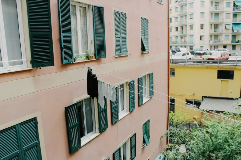 green windows and shades in front of buildings