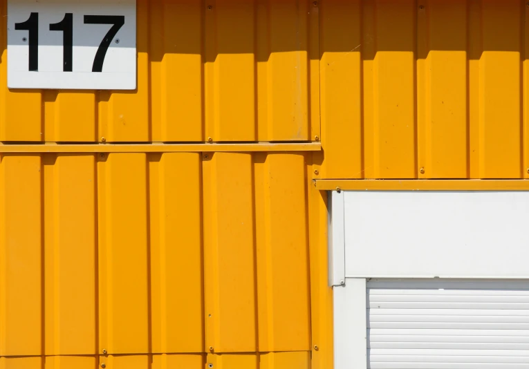 a yellow wall with two closed garage doors