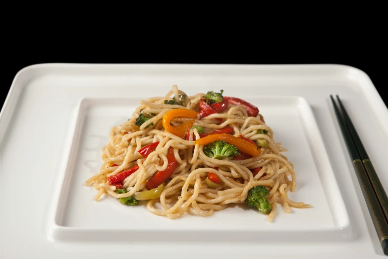 a square white plate holds broccoli and peppers