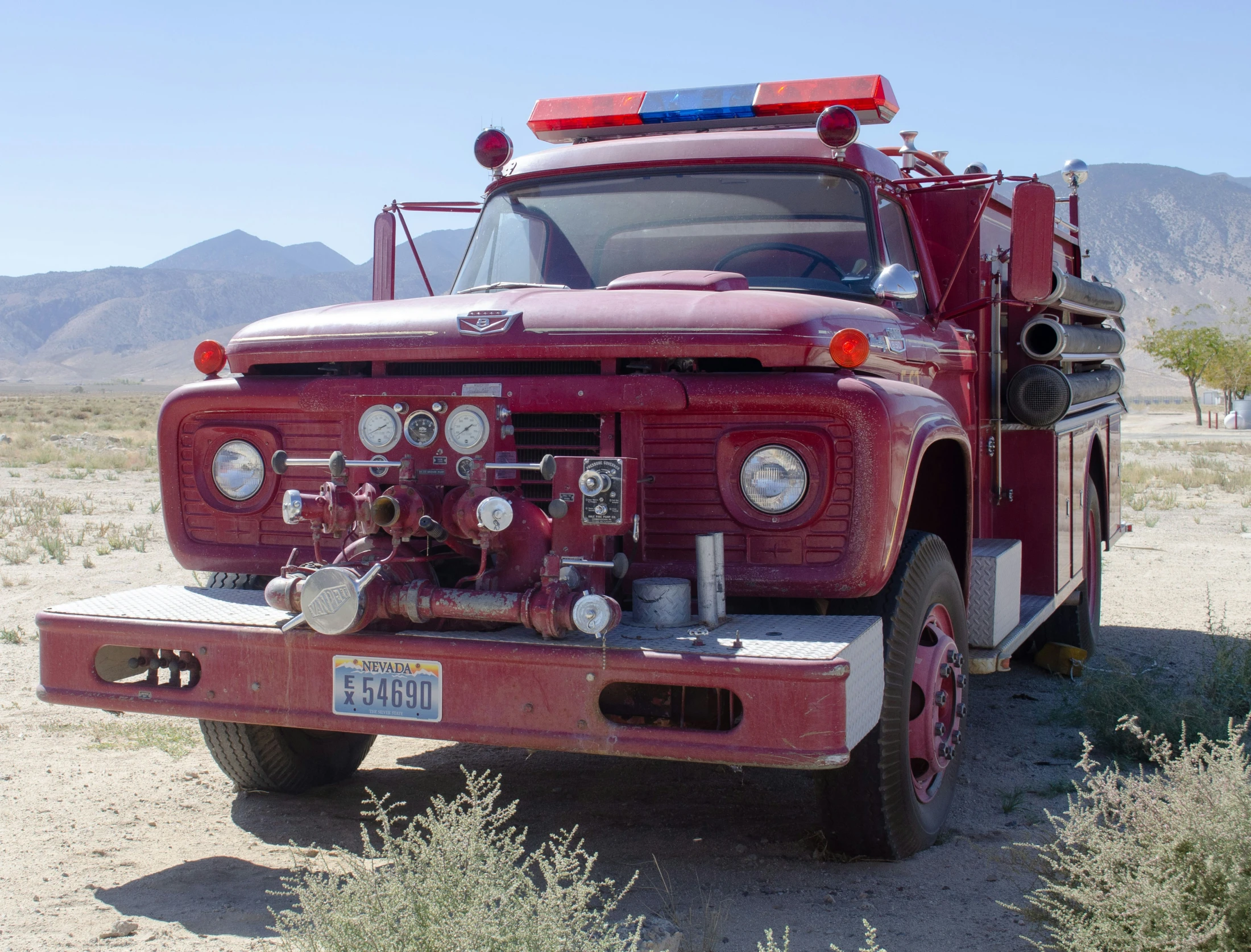 an old red fire truck parked on the side of the road