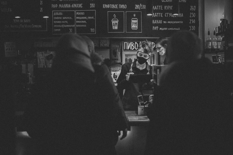 a person at a bar and a man preparing a drink