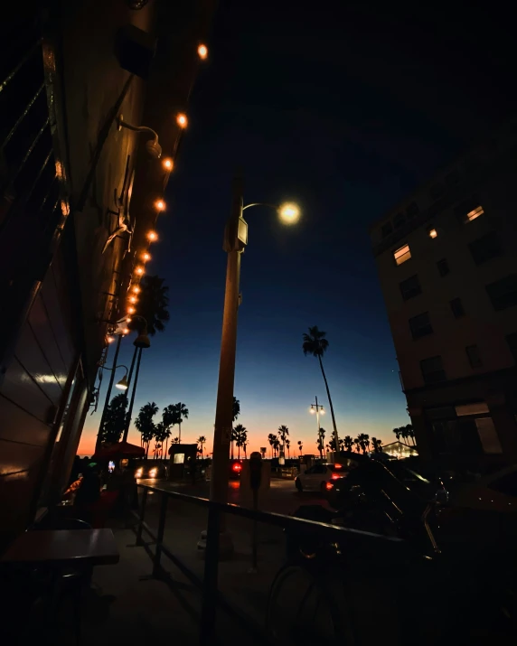 a street is dimly lit with a bright light from the street lights