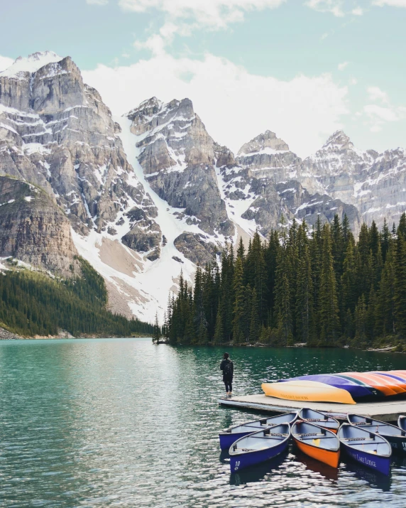 many canoes and some people near the water