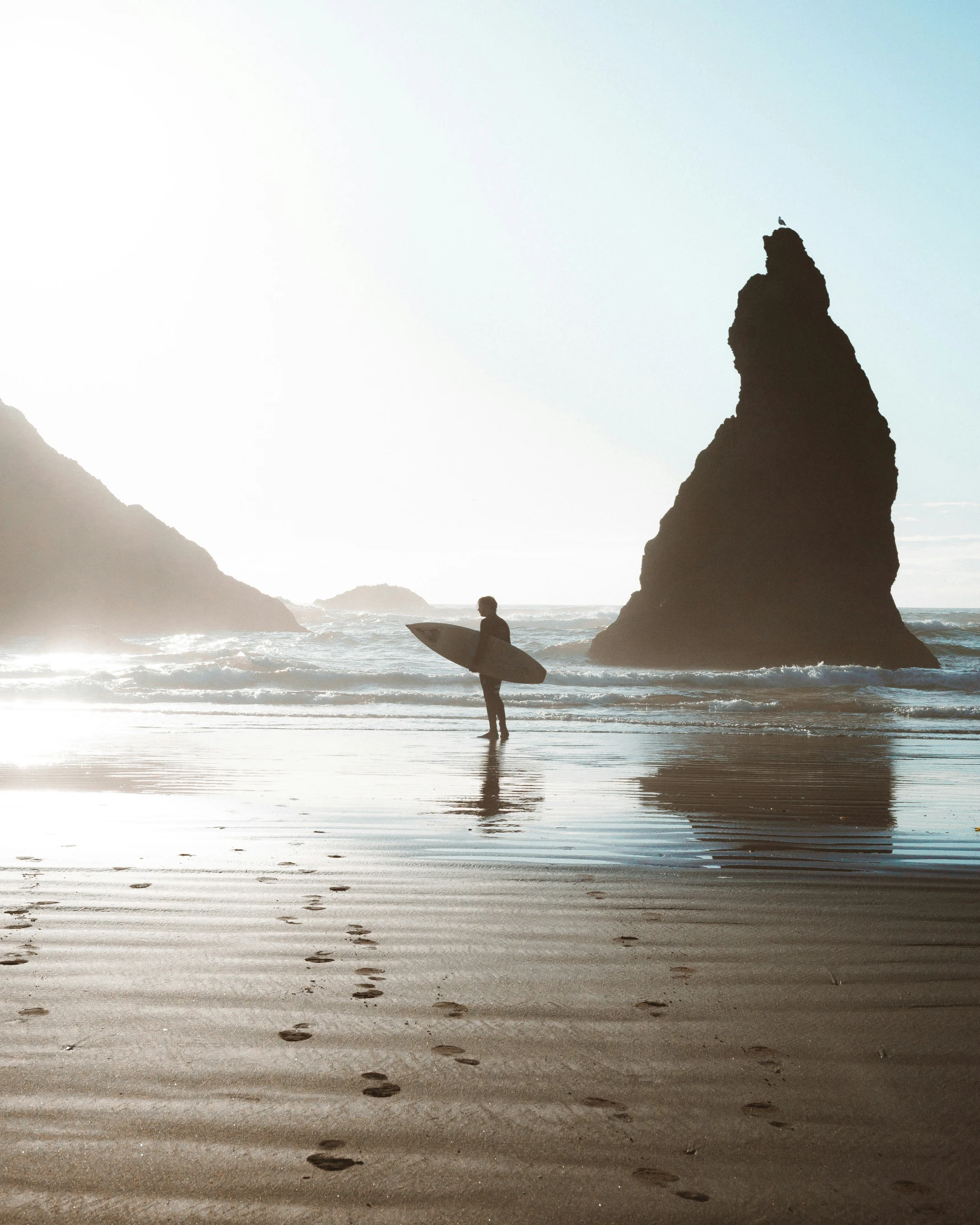 a person with a surfboard walking towards a body of water