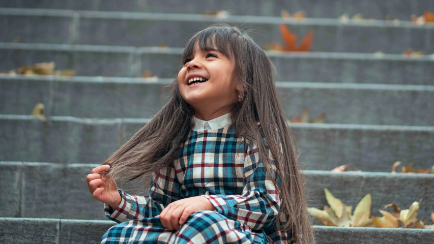 a  sitting on the stairs laughing