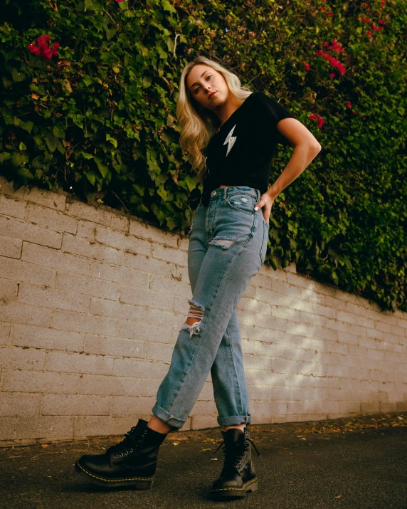 a woman is walking on the sidewalk in jeans and black top