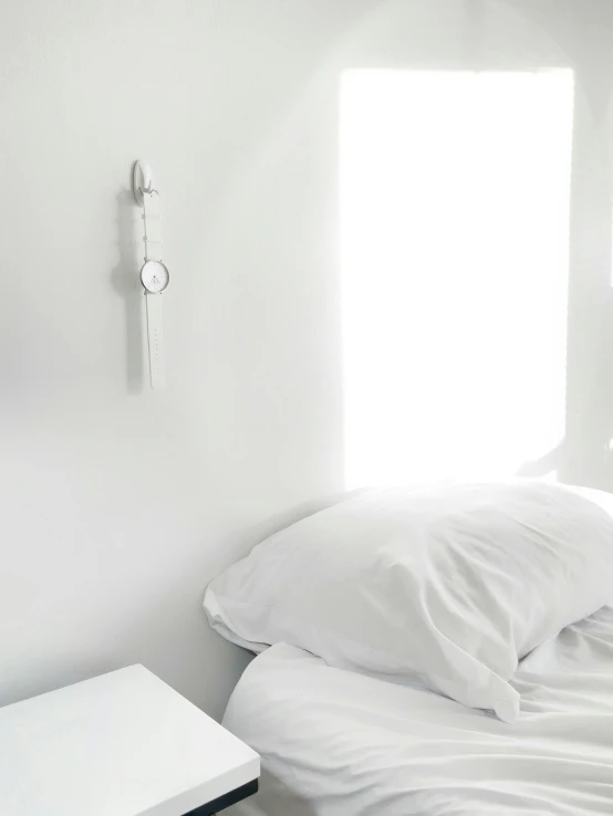 an alarm clock mounted on the wall next to a bed