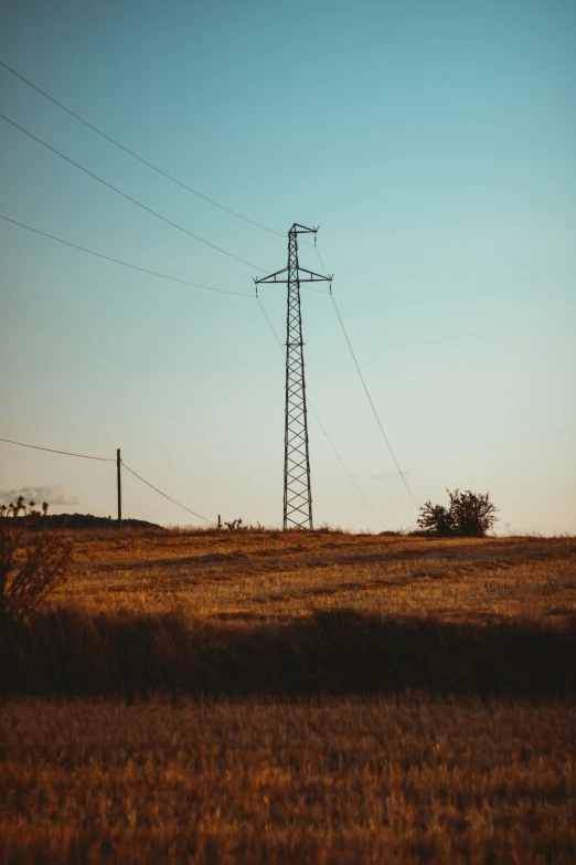 a tower sitting in a field that has power lines