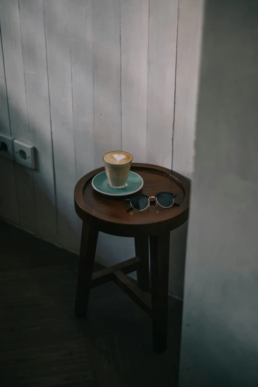 a cup of coffee sitting on top of a wooden table