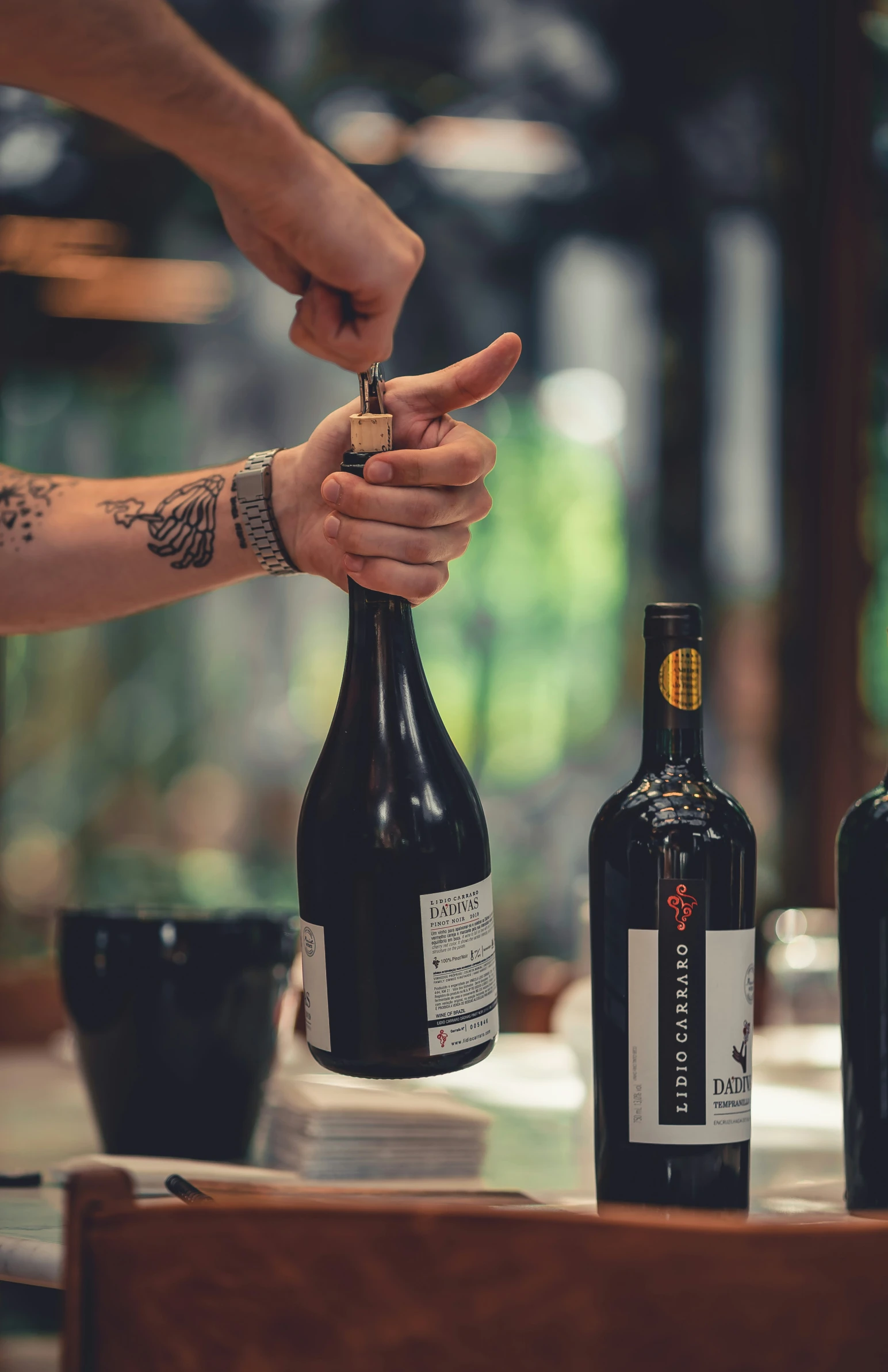 a man holding his finger toward a wine bottle in the air