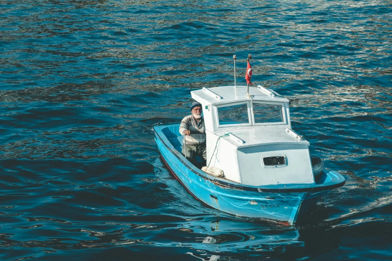 a small boat sails in the ocean, making its way to shore