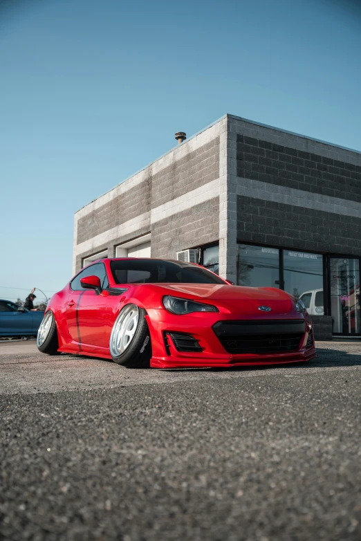 the red car is parked in front of the building