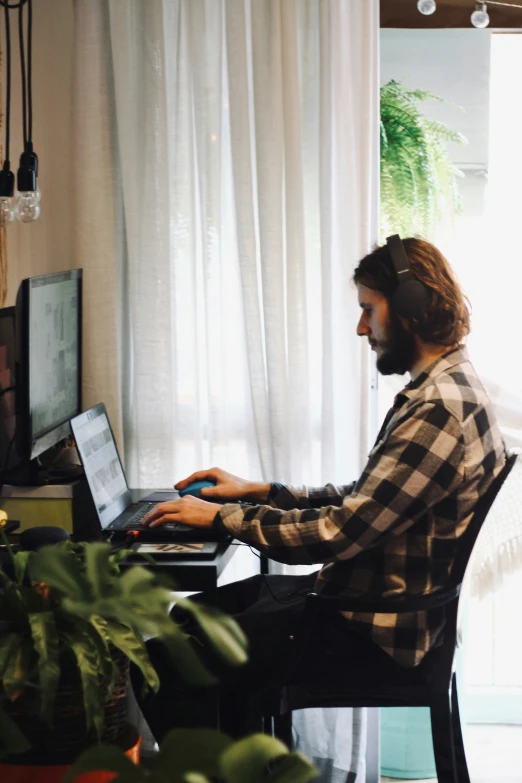 a man sits in front of a computer in his living room