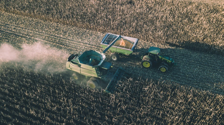 a large farm field being cultivated next to a tractor