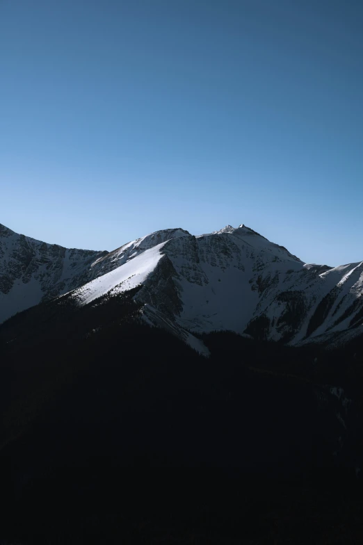 a snow covered mountain with very tall snowy mountains