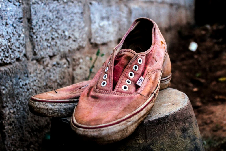 a pair of red shoes sit in front of a brick wall