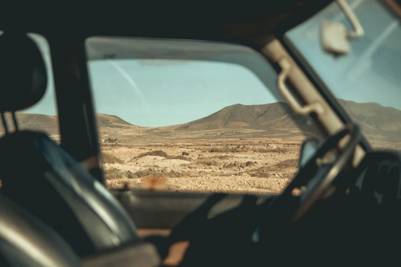 view from a cab window of a field with mountains