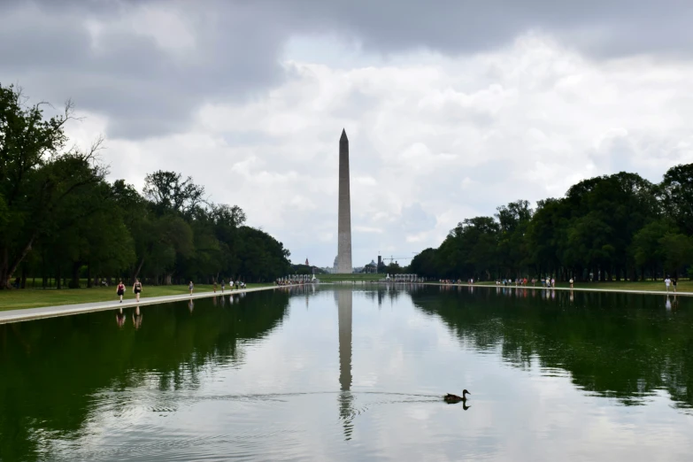 the washington monument stands tall among a large expanse of water