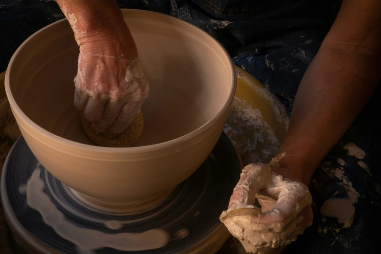 a person working with clay on a pottery wheel