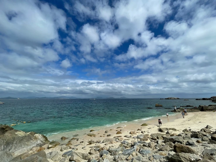 people enjoying an ocean view from the rocks on a cloudy day