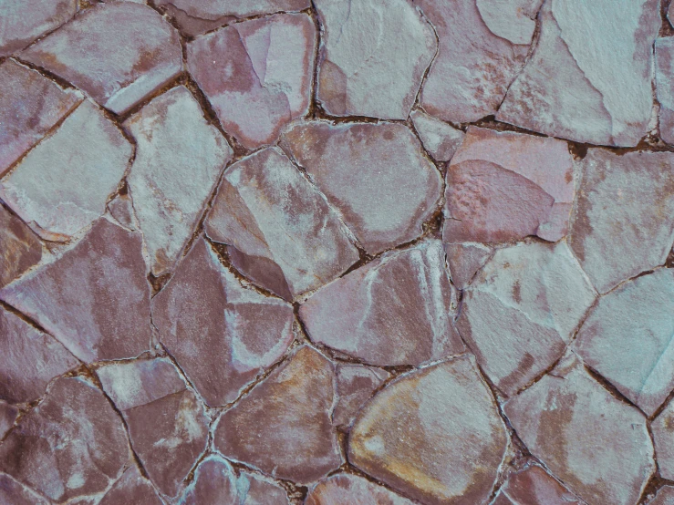 a brick - like background is painted in brown, pink and blue