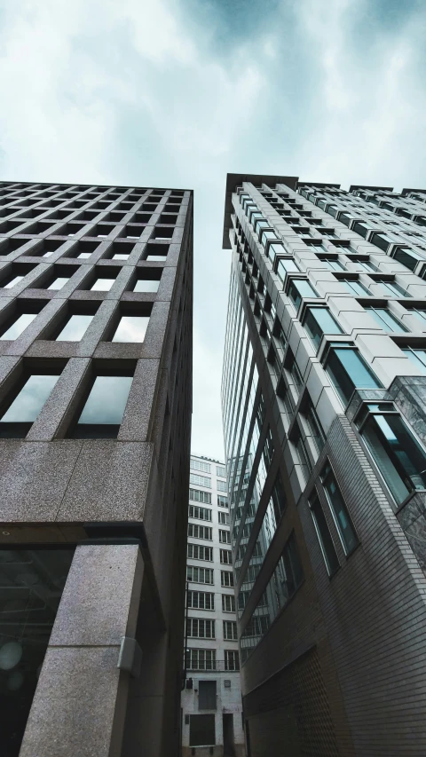 two tall buildings against a blue cloudy sky