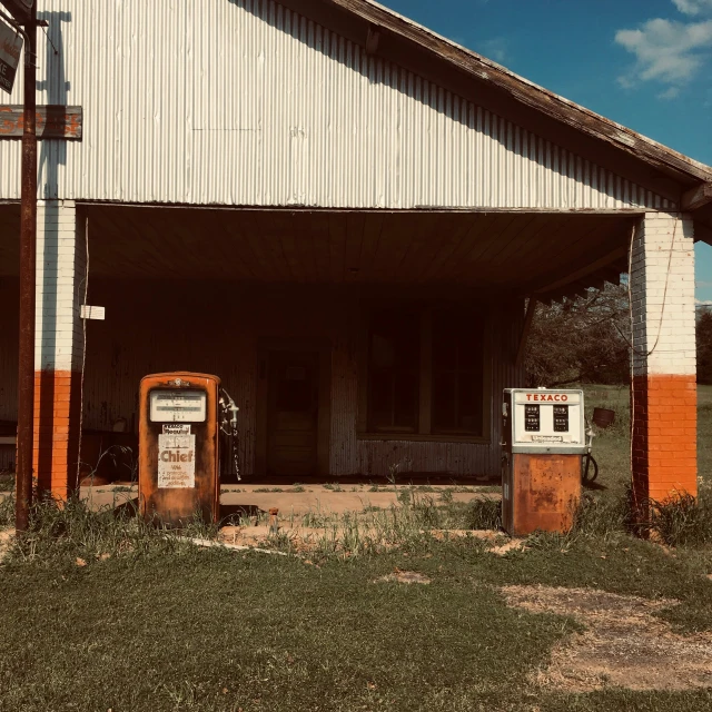 an old church with two signs for the gas pump