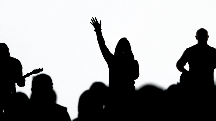 a shadow shows the group of people playing guitar