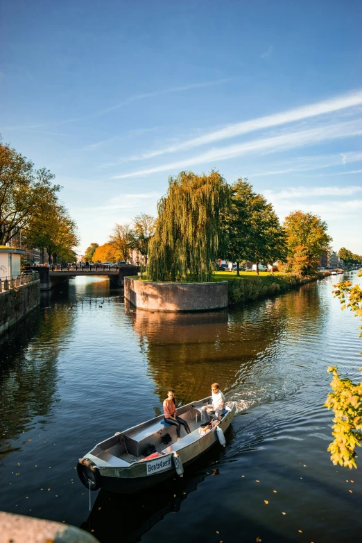 a man driving a boat on a river near trees