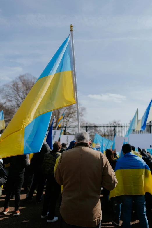 a group of people standing with flags and a clock tower in the background