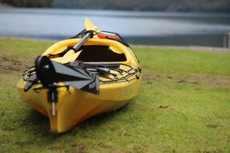 a yellow canoe on the grass with an umbrella