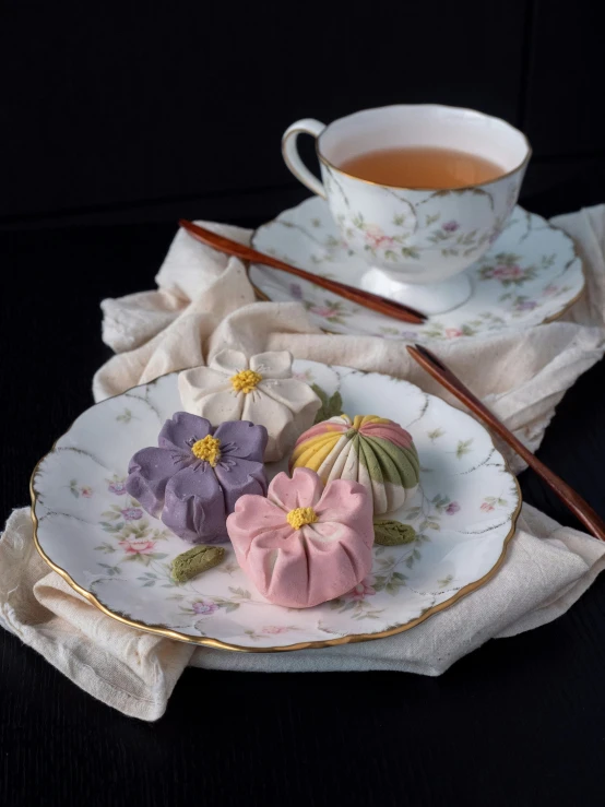 a tea cup, two saucers with chopsticks, and an art nouveau plate