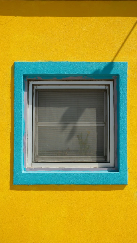 a window on a yellow and blue building