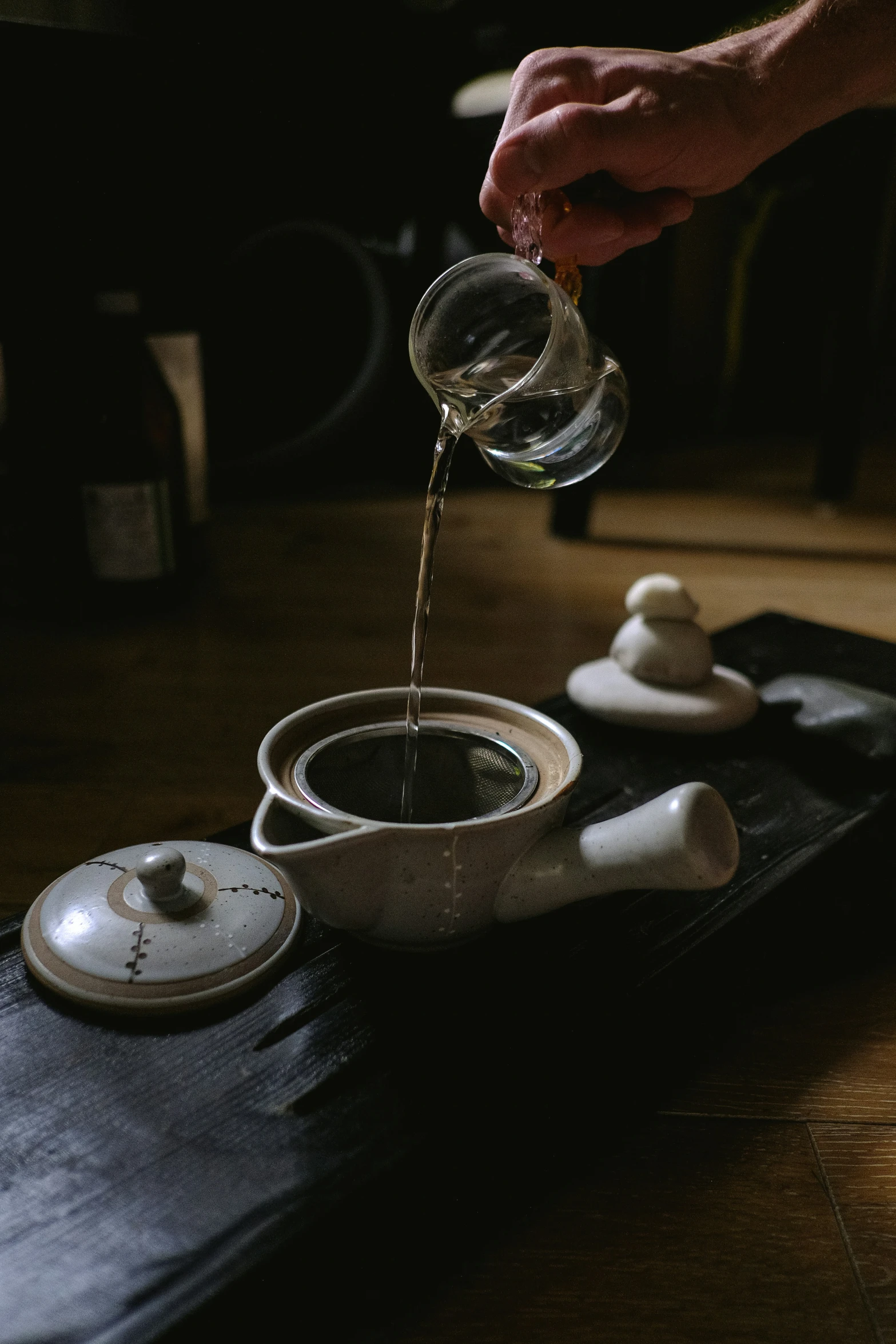 a person pouring soing into a bowl on a plate