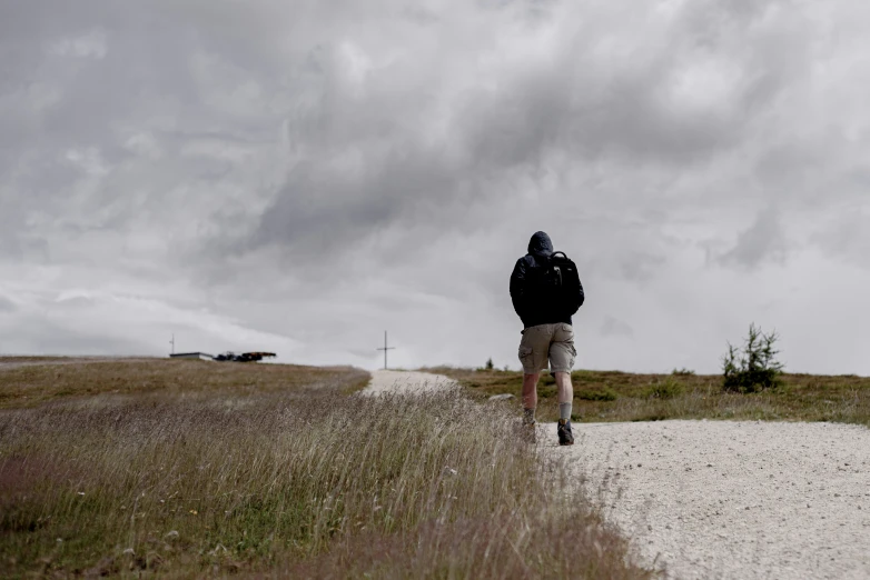 a man is walking down a dirt road