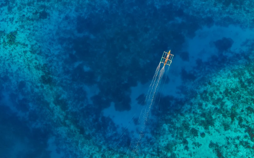 a boat traveling across a blue ocean under a sky