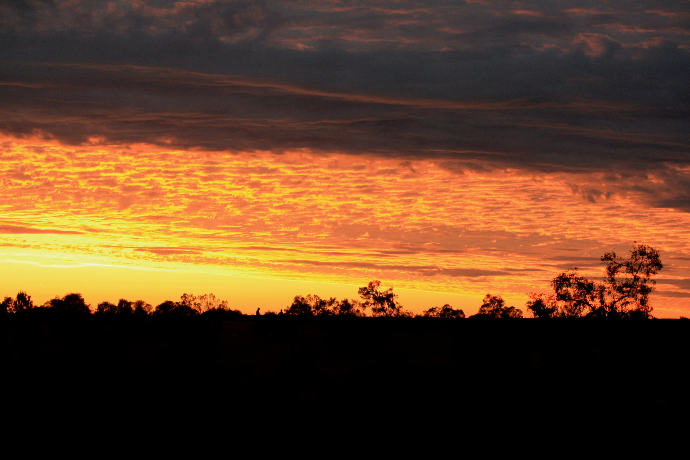 the sky has a sun set with some clouds