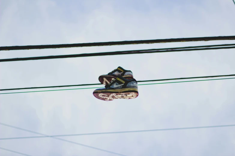 a pair of shoes hanging on an electric wire