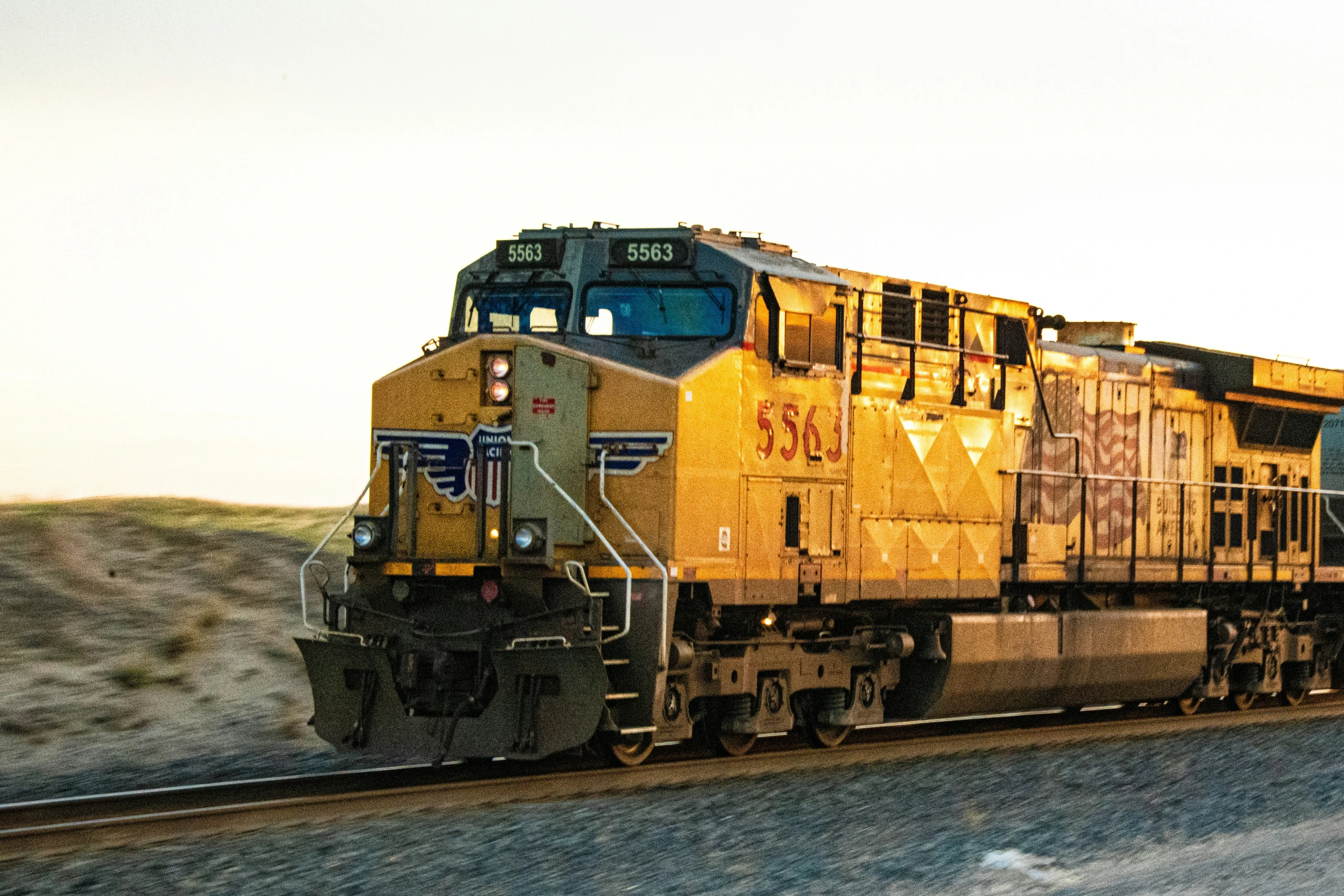 a cargo train is on the tracks in the desert