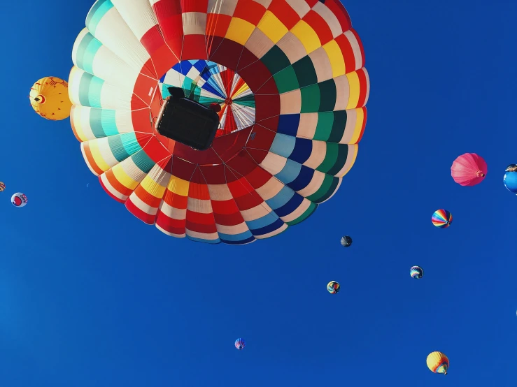 several balloons fly through the air in the daytime