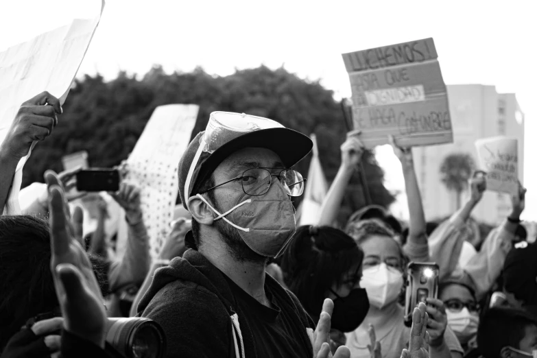 people are holding up signs and wearing masks