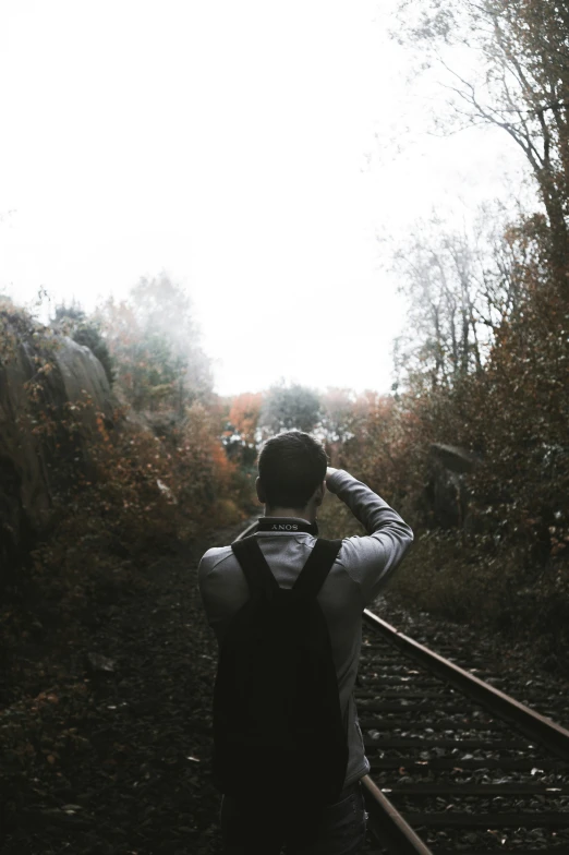 a man stands with his back to the camera and looks up at the sky